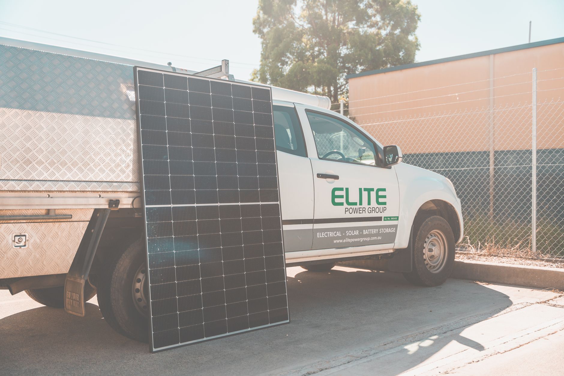 Elektriker montiert Photovoltaik-Module auf einem Wohnhausdach