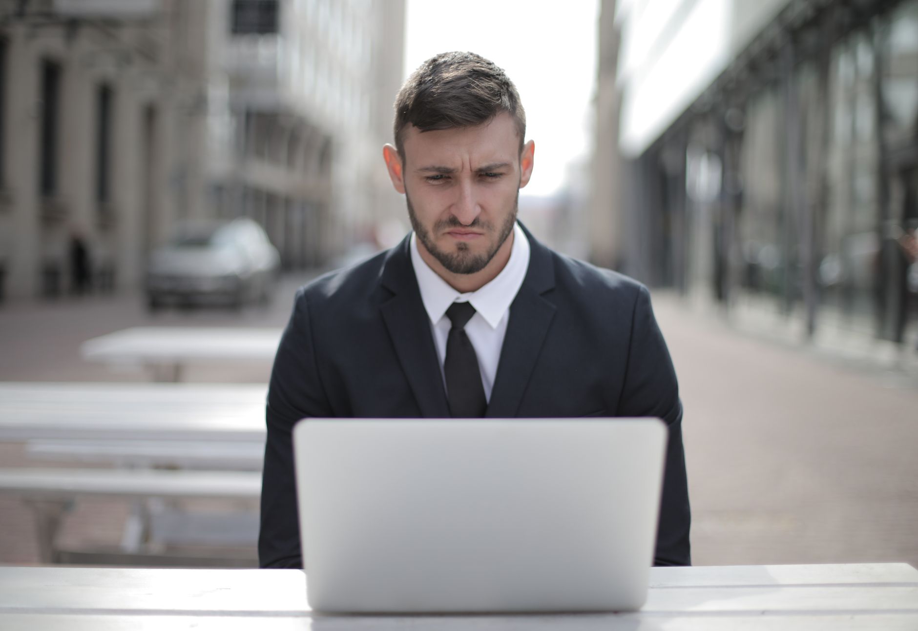 Betriebsinhaber sitzt nachdenklich vor Laptop mit Bewerbungen